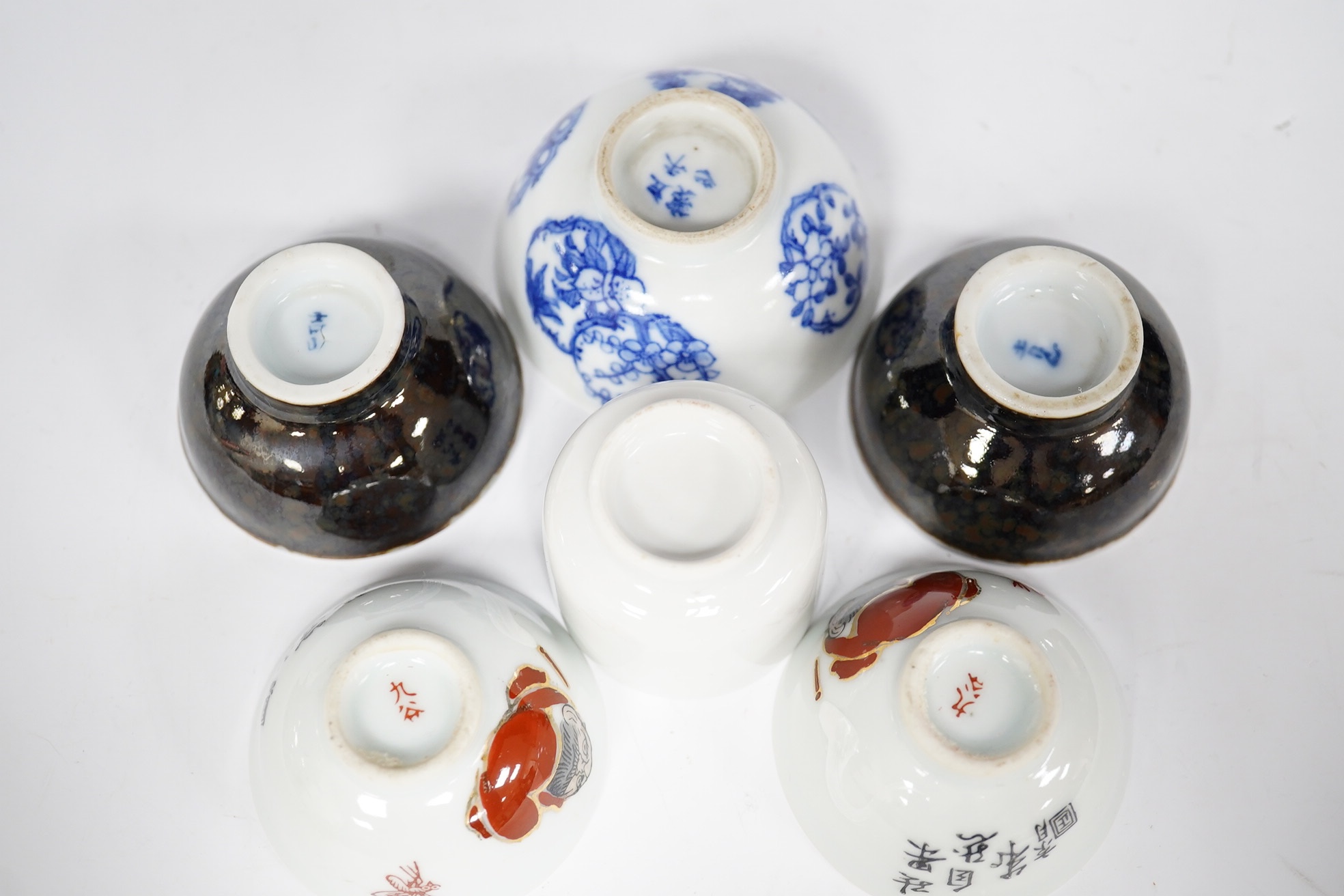 Six Japanese sake bowls, two pairs and two single, tallest 4cm. Condition - some chips